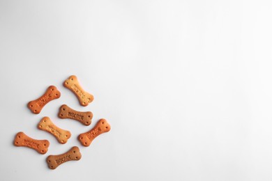 Photo of Bone shaped dog cookies on white background, top view. Space for text