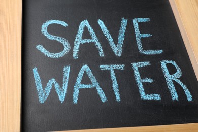 Photo of Words Save Water written on blackboard, closeup