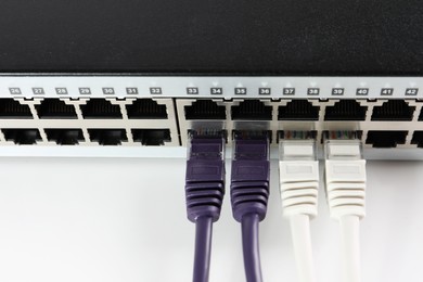 Photo of Closeup view of network switch with cables on light background. Internet connection