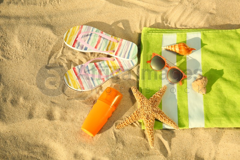 Flat lay composition with stylish beach accessories on sand