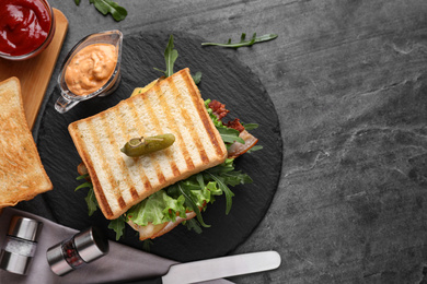 Tasty sandwich with toasted bread served on grey table, flat lay. Space for text