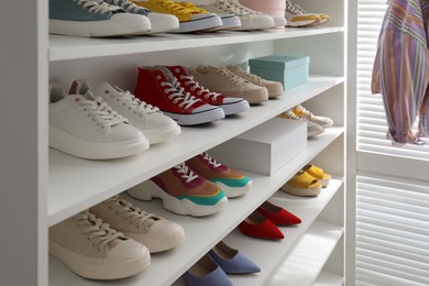 White shelving unit with collection of colorful sneakers indoors