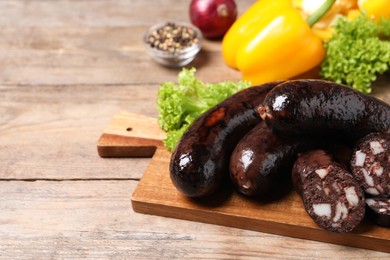 Tasty blood sausages served on wooden table, closeup. Space for text