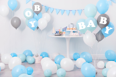 Baby shower party for boy. Tasty treats in room decorated with balloons