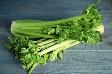 Photo of Fresh ripe celery on blue wooden table