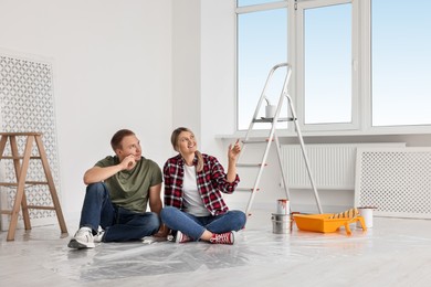 Photo of Happy couple discussing interior details in apartment during repair, space for text