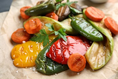 Delicious grilled vegetables with parsley on parchment, closeup