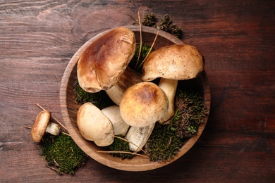 Fresh wild porcini mushrooms on wooden table, top view