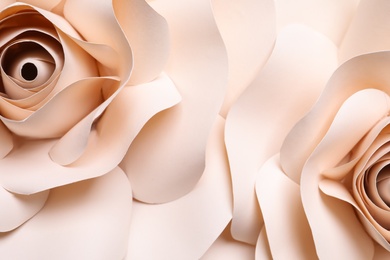 Beautiful beige flowers made of paper as background, top view
