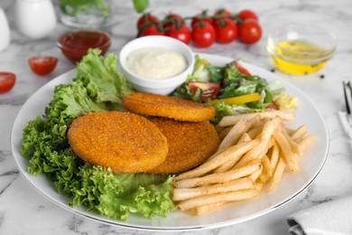 Delicious fried breaded cutlets with garnish served on white marble table