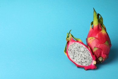 Photo of Delicious cut and whole white pitahaya fruits on light blue background. Space for text