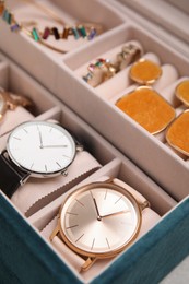 Elegant jewelry box with beautiful bijouterie and expensive wristwatches, closeup