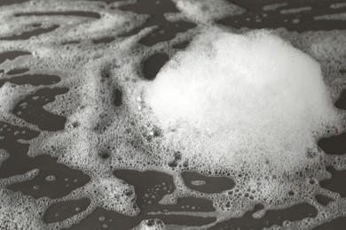 Fluffy bath foam on grey background, closeup view