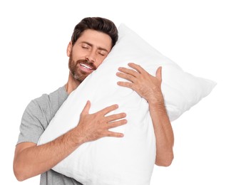 Sleepy handsome man hugging soft pillow on white background