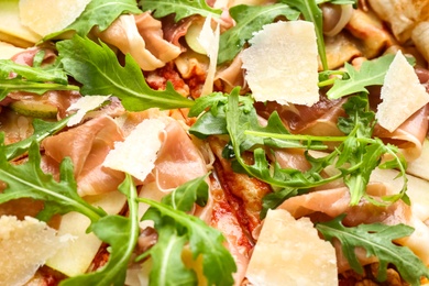 Tasty pizza with meat and arugula as background, closeup