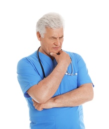 Portrait of pensive male doctor in scrubs with stethoscope isolated on white. Medical staff