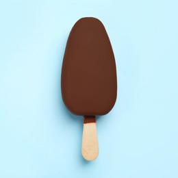 Ice cream glazed in chocolate on light blue background, top view