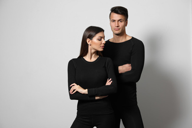 Couple wearing thermal underwear on light grey background