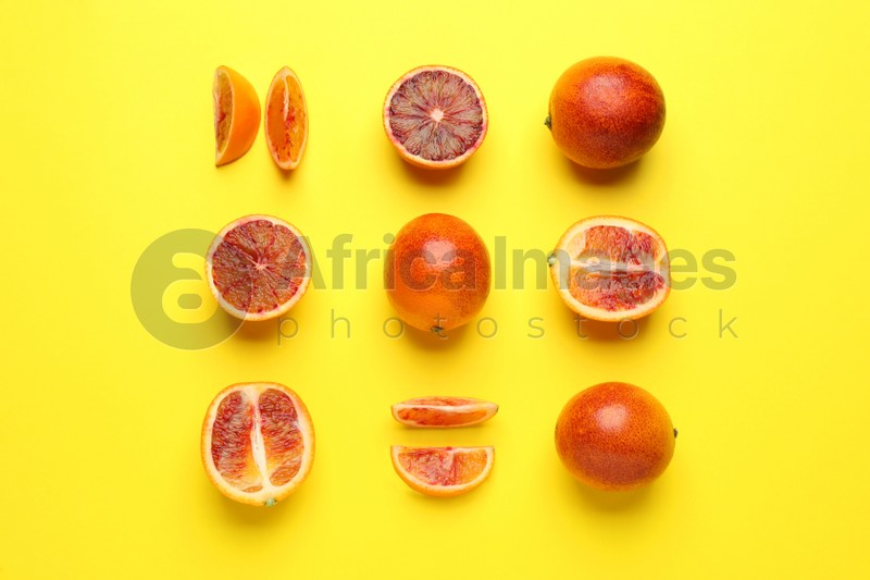 Many ripe sicilian oranges on yellow background, flat lay