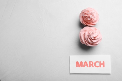 8 March greeting card design with cupcakes and space for text on light grey background, flat lay. International Women's day