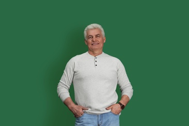 Portrait of handsome mature man on color background