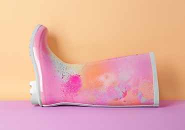 Gumboot on color background. Female shoes