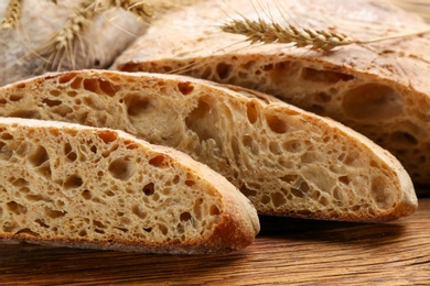 Tasty freshly baked bread on wooden table, closeup