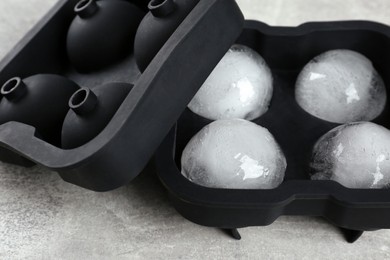 Frozen ice balls in mold on grey table, closeup