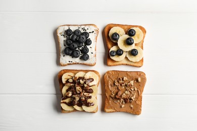 Photo of Different sweet delicious toasts on white wooden table, flat lay