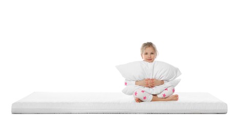 Little girl hugging pillow on mattress against white background