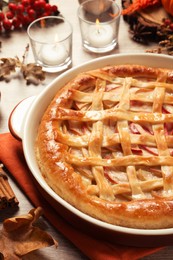Delicious homemade apple pie and autumn decor on wooden table, closeup. Thanksgiving Day celebration