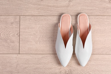 Photo of Pair of female shoes on wooden background, top view