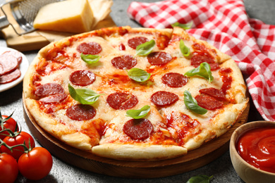 Hot delicious pepperoni pizza on grey table