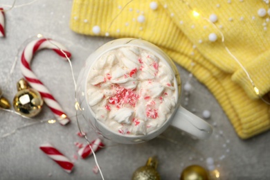Photo of Flat lay composition with delicious marshmallow drink, festive decor and yellow sweater on light grey table