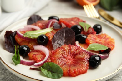 Photo of Plate of delicious sicilian orange salad on grey table, closeup