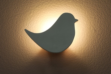 Bird shaped glowing night lamp on wall