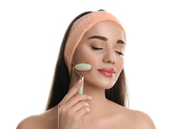 Woman using natural jade face roller on white background