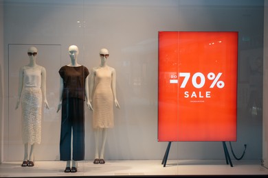 Photo of Siedlce, Poland - July 26, 2022: Sale sign on red stand in showcase at shopping mall. Seasonal discount offer