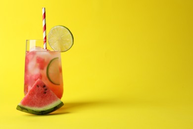 Photo of Tasty summer watermelon drink with lime in glass on yellow background. Space for text