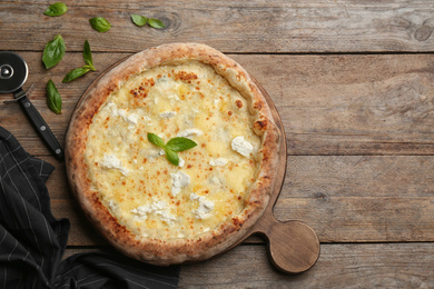 Photo of Delicious cheese pizza on wooden table, flat lay