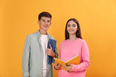 Teenage students with stationery on yellow background