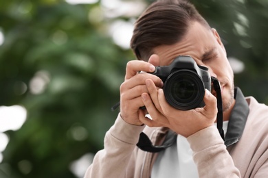 Male photographer with professional camera on blurred background. Space for text