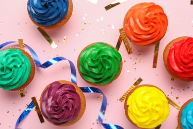Flat lay composition with delicious colorful cupcakes and confetti on pink background