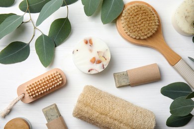Eco friendly personal care products and leaves on white wooden table, flat lay