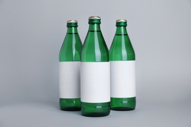 Glass bottles with soda water on light background