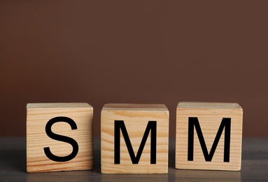 Cubes with abbreviation SMM (Social media marketing) on grey table