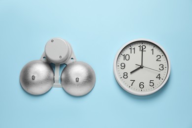 Modern electrical school bell and clock on light blue wall