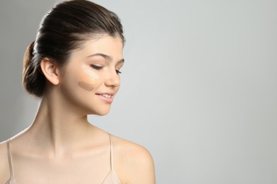 Beautiful girl on light grey background. Using concealers and foundation for face contouring