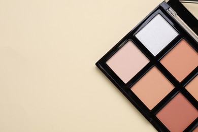 Photo of Colorful contouring palette on beige background, top view with space for text. Professional cosmetic product