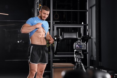 Photo of Man showing his abs on camera at gym. Online fitness trainer